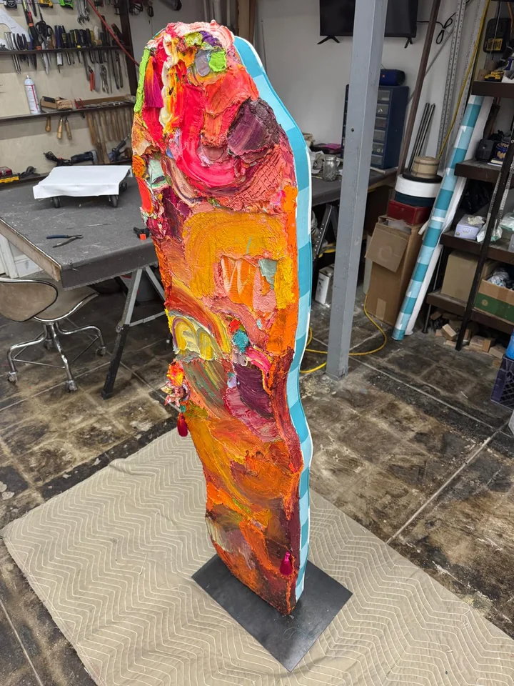 Tall upholstered panel covered in bright orange, pink, and turquoise patterned fabric