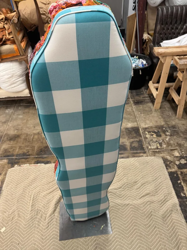 Front view of a tall turquoise and white checked upholstered panel